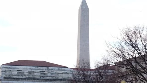 Panning down Washington Monument from behind buildings and trees