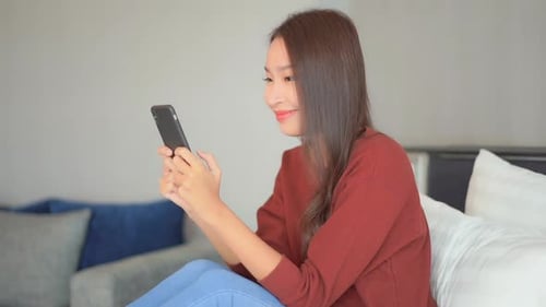 A close-up of a pretty young woman texting on her smartphone.