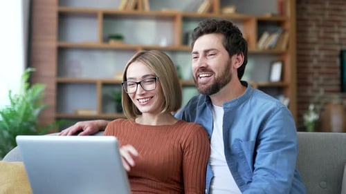 Smiling Couple Video Calling on Laptop at Home