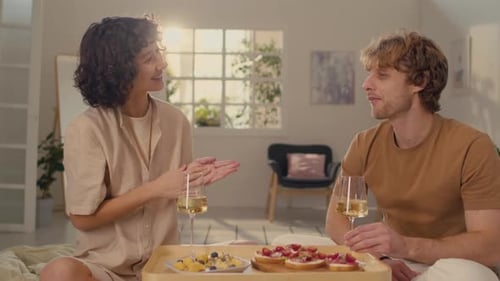 Young Couple Enjoying Breakfast in Bed Together