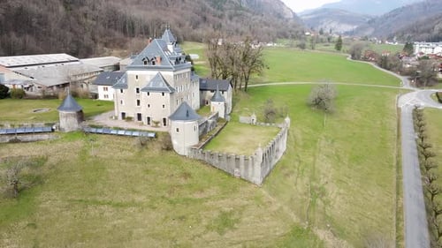 Castle on a green field with towers, fences and gardens