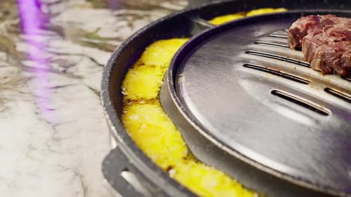 close up of delicious appetizing juicy piece grilled cheese being fried in korean restaurant