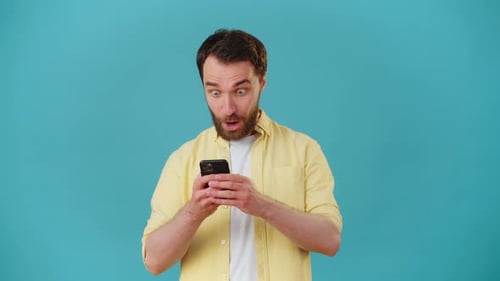 Excited Man Celebrating While Using Mobile Phone