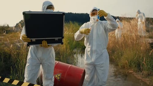 Environmental Scientists Engaged in Detailed Field Research While Wearing Protective Gear
