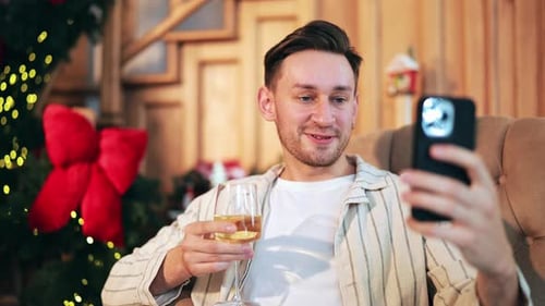 Man holding wine video chatting during the holidays