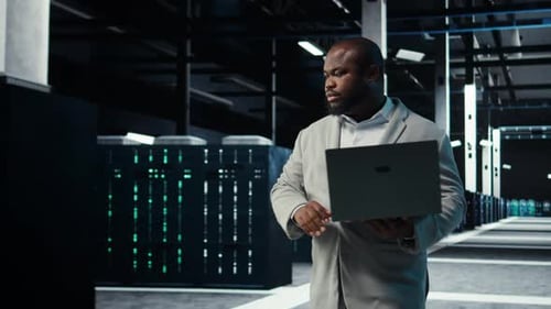 Data Center Admin Coding Writing Script on Laptop Identifying Bottlenecks