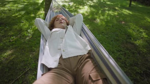 Woman Relaxing in Hammock Underneath Shady Trees