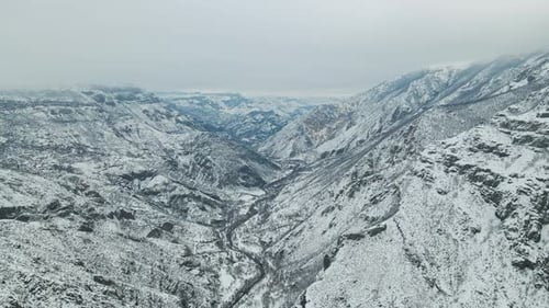 Aerial Scenic Flight of Stunning Glorious Mountains White Snow Covered Rocks and Cloudy Sky Weather