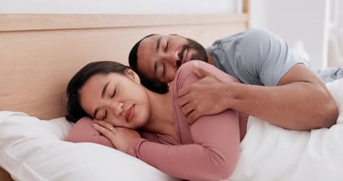 Couple Sleeping Peacefully in Bed Together