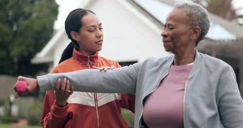 Young Adult Woman Helping Senior with Arm Exercises