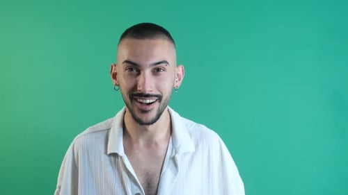 Surprised Man Smiles Against a Green Background