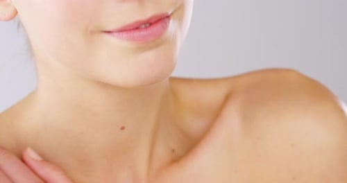 Woman Applies Lotion to Her Shoulder