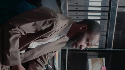 Man Concentrating and Reviewing Documents in Office