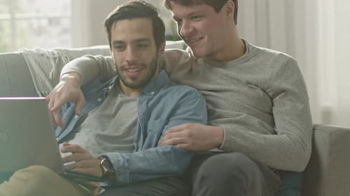 Affectionate men using a laptop at home