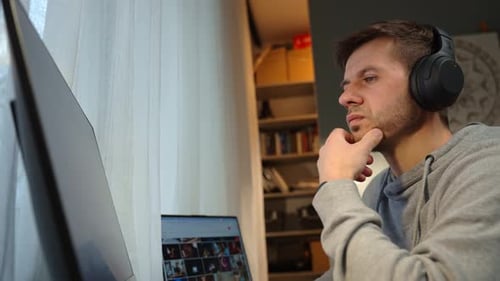 Man Working on Computer with Headphones at Home Office Desk
