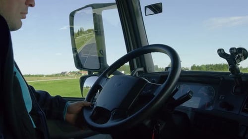 Inside of the Cabin View of the Professional Truck Driver Driving His Big Vehicle on the Road.