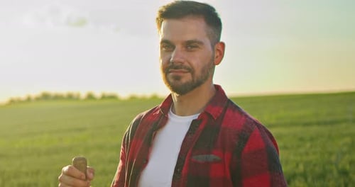Portrait View of the Caucasian Bearded Gardener Examining Field and Looking to the Camera at the
