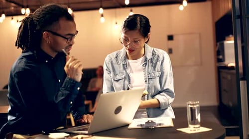 Colleagues Working Together At Laptop in Workplace