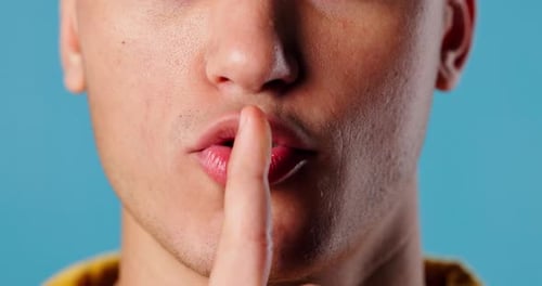 Secret, mouth and man in studio with smile for quiet, gossip or confidential information