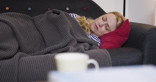 Blonde Woman Sleeping Peacefully on Couch Indoors