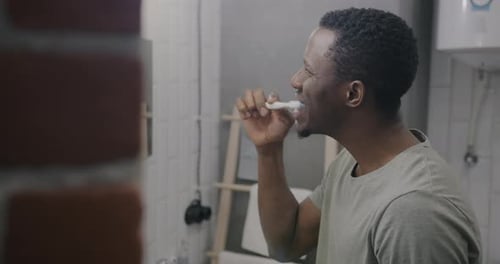 Man Brushing Teeth in a Home Bathroom