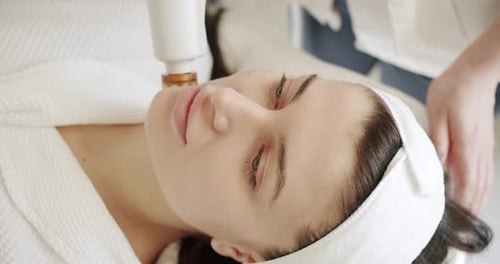 Woman Receiving Facial Treatment with Modern Equipment