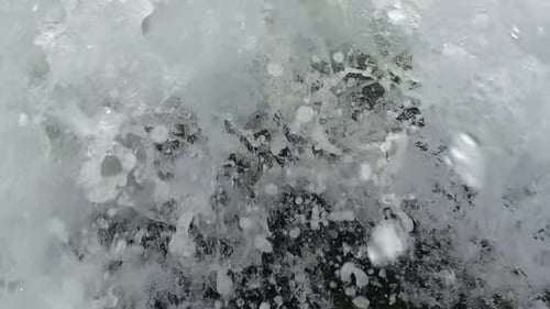 Große Welle stürzt vor der Kamera an der Küste des grünen Sandstrandes ab