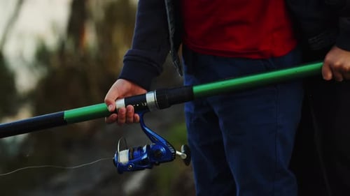 Close Up Little Hands Reel Fishing Rod in Front of Lake Hobby Catching Fish Schoolboy Enjoying Wild