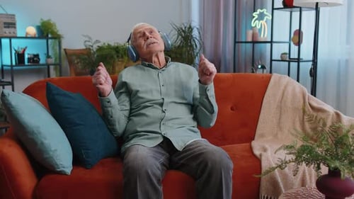 Energetic Senior Man Listening to Music at Home
