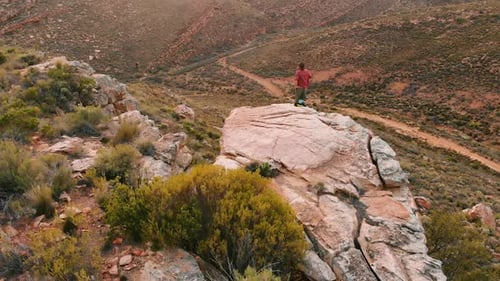 A Caucasian man celebrates on a mountain peak, with copy space