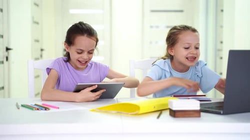 Two Children Do Homework at Home One with a Tablet and the Other with a PC