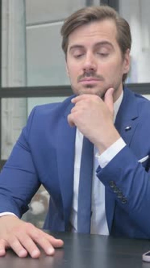 Pensive Man in Suit Thinking at Office Desk