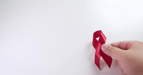 Placing a red ribbon on the right side of the frame which signifies the HIV-AIDS worldwide disease a