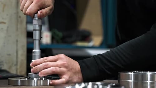 Worker Measures Metal Part with Precision Tool