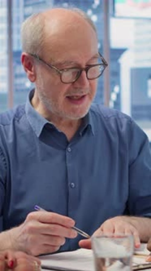 Senior Man Signs Contract at Office Meeting