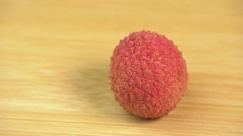 Frische Litschifrüchte in der Schale rotieren im Makro auf Holzgrund. Litschibeeren
zur Herstellung