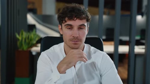 Smiling Young Man with Curly Hair in Office