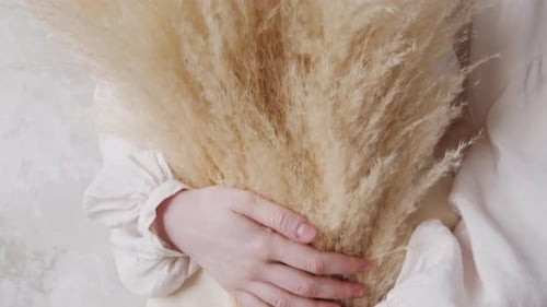 Woman with Blonde Hair Holds Pampas Grass