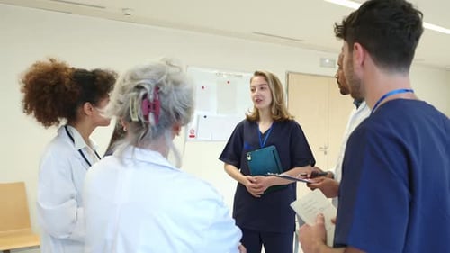 Medical Team Discussing Patient Information in Hospital Corridor