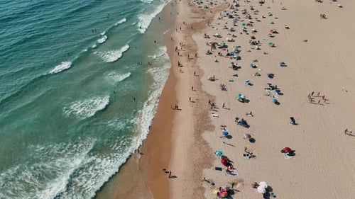 A Stunning Aerial View of a Picturesque Beach Featuring Sunbathers and Colorful Umbrellas