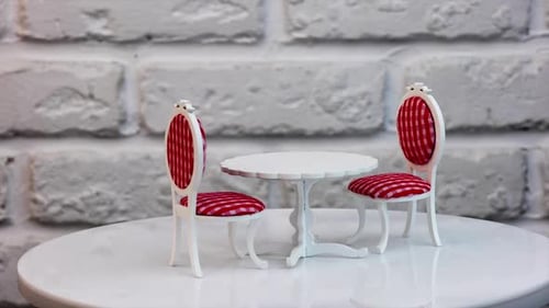 Carved wooden toy table and two chairs at both sides rotating. Pretty furniture for a dolly house.