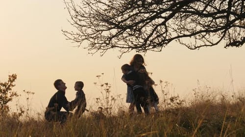 Happy Kids Rushes Into Hands of Parents Parents Hugs Their Kids in the Meadow