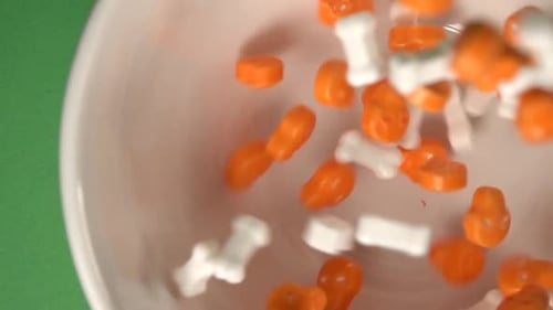 Halloween Candy Falling into a White Bowl