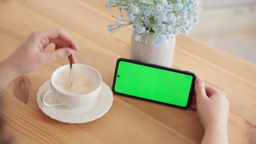 Woman Use Green Screen for Copy Space Closeup Chroma Key Mockup on Horizontal Smartphone in Hand