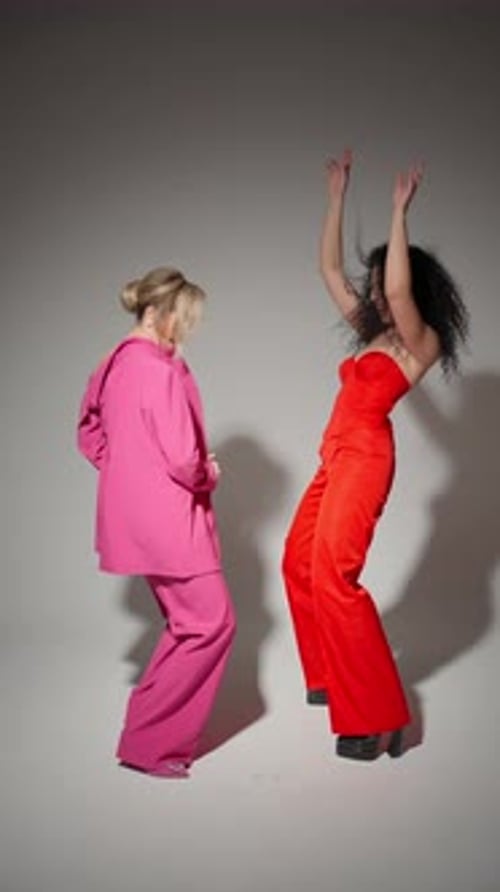 Frauen in rosafarbenen und roten Klamotten tanzen und bewegen sich im Frame Dance-Konzeptstil