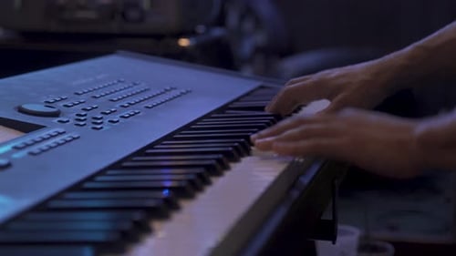 handheld orbit from static shot of a man playing keys on stage in 4K