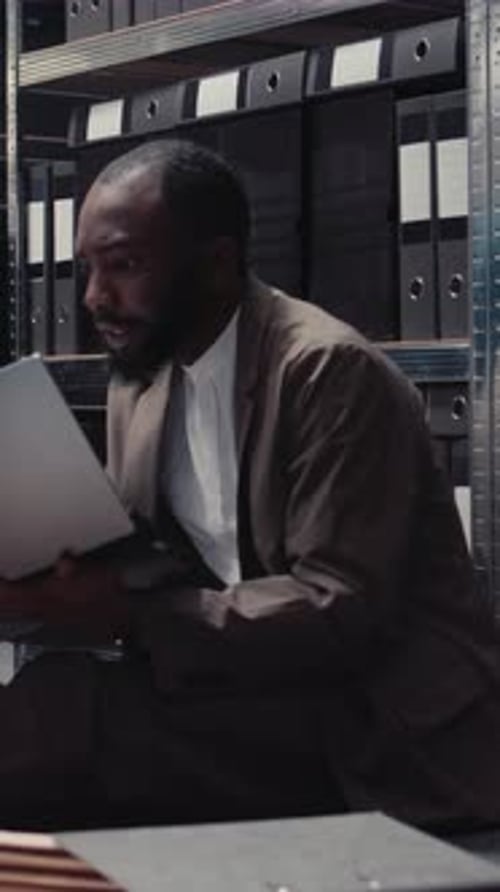 Young Adult Examining Files in Archive Room