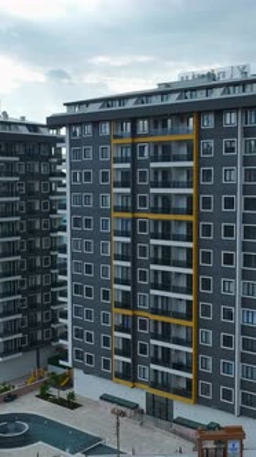 Vista aérea vertical de vídeo de un edificio residencial contemporáneo con balcones en un entorno natural brillante