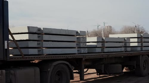 Truck Carries Concrete Blocks at Construction Site on Sunny Day
