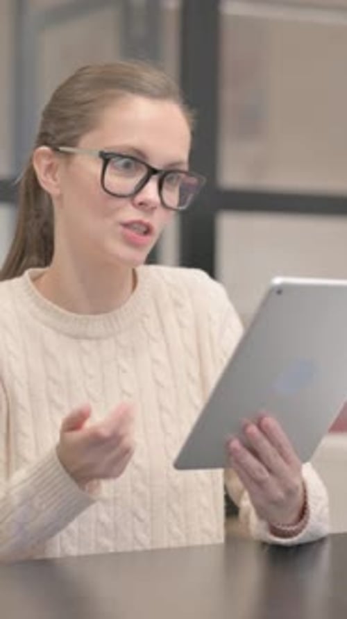 Young Woman Doing Video Chat on Tablet in Office